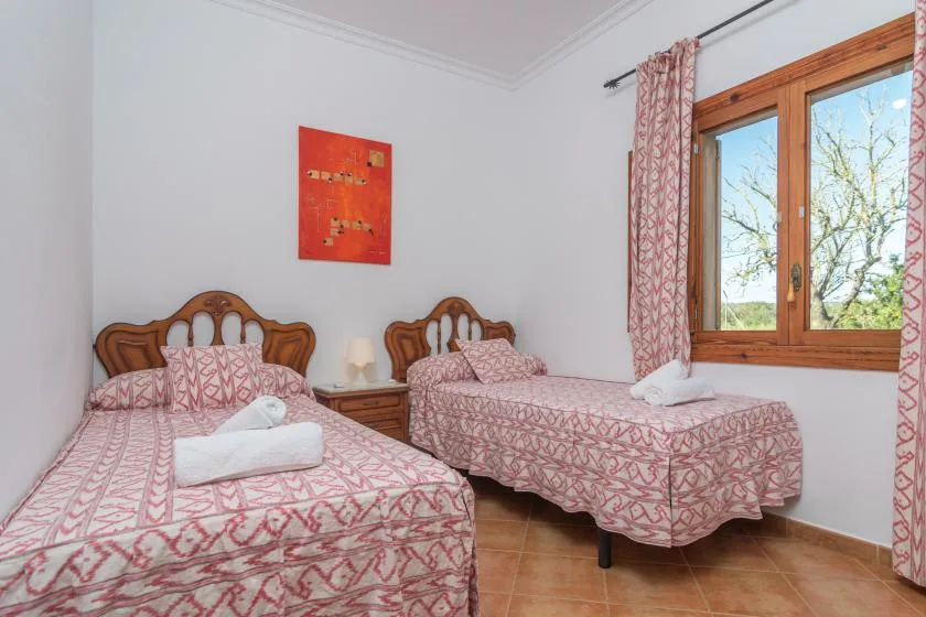 A bedroom with two beds dressed in matching patterned bedding.