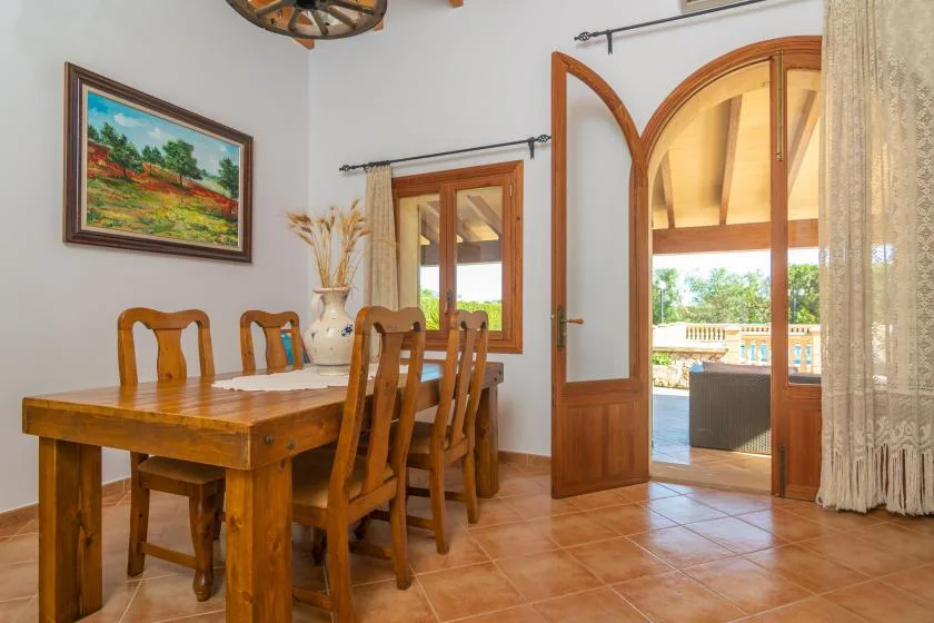 A dining area with a wooden table beside an open arched doorway.