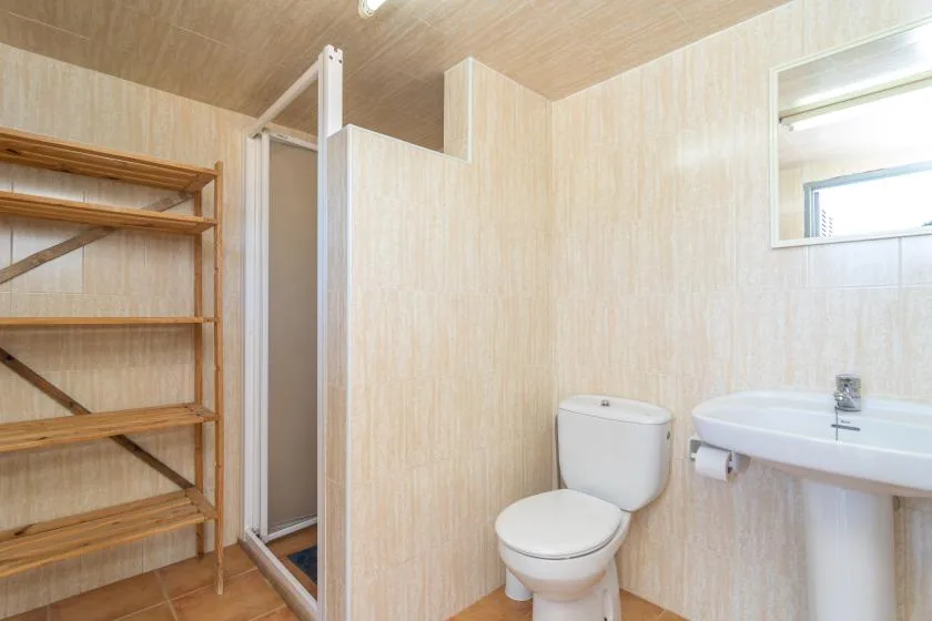 A bathroom with a toilet, sink, and shower.