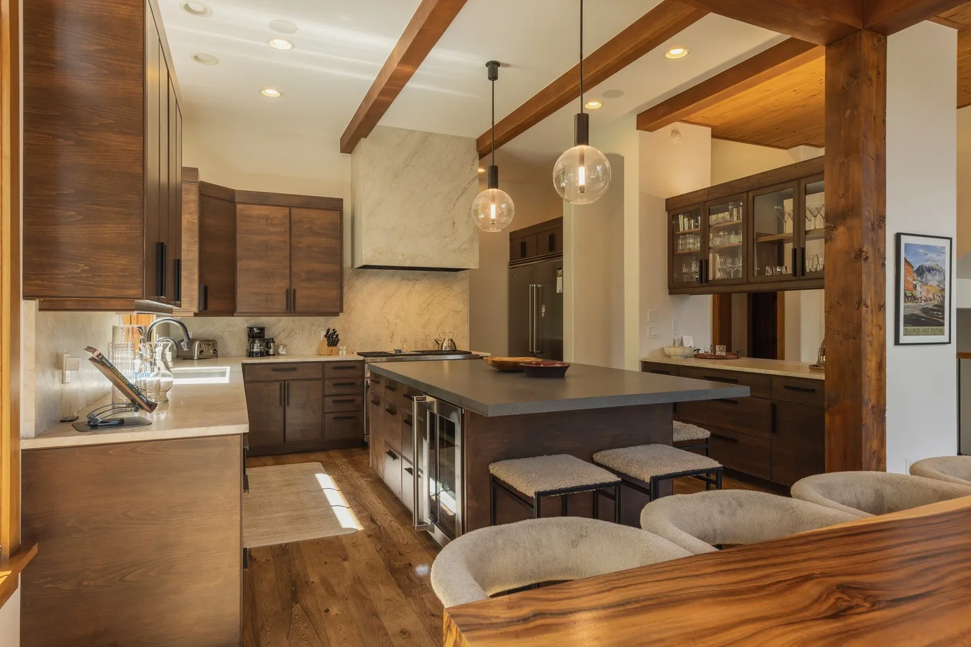 A warm-toned kitchen with a large island and wooden cabinetry.