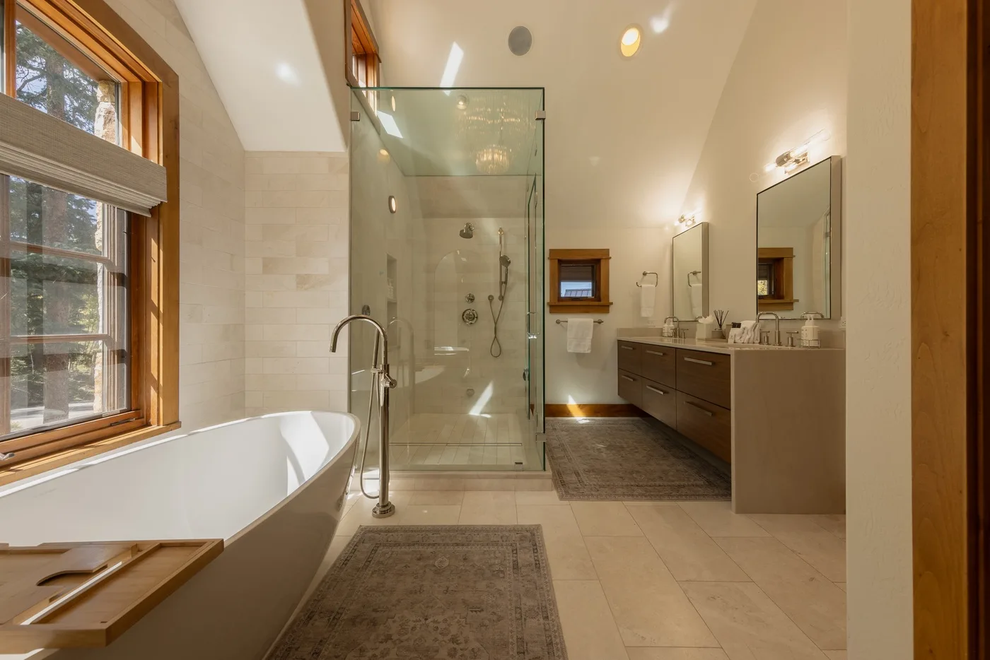 A bright bathroom with a freestanding bathtub, glass shower, and double vanity.