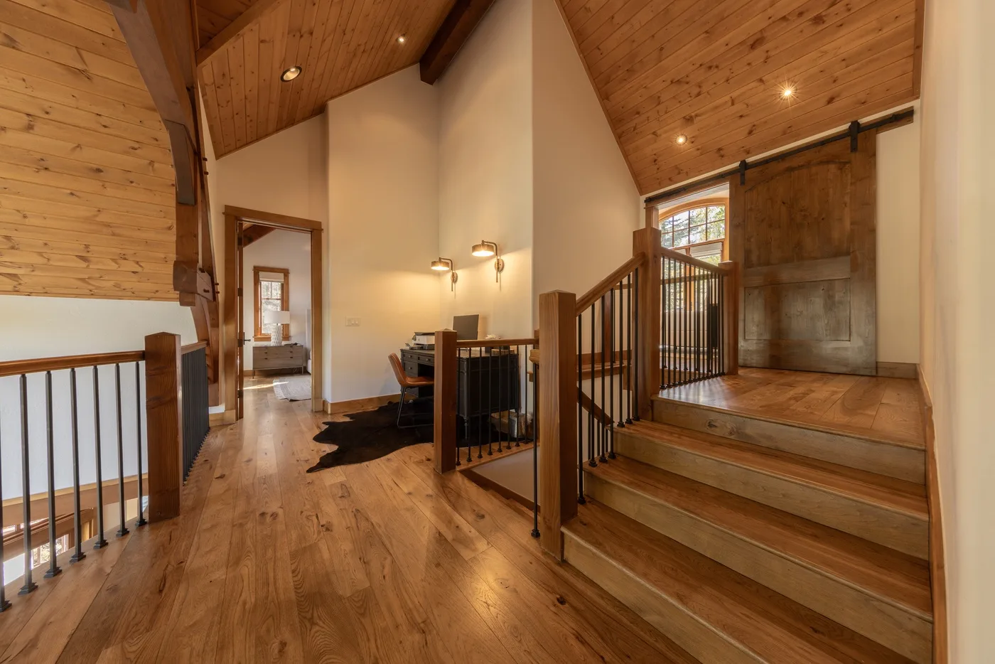 A wood-paneled interior with a raised landing, stairs, and a small dining area.
