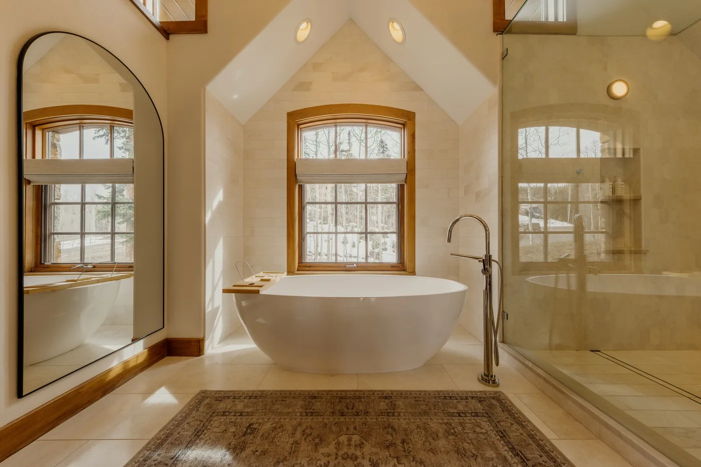 A bright bathroom features a freestanding bathtub beneath a window.