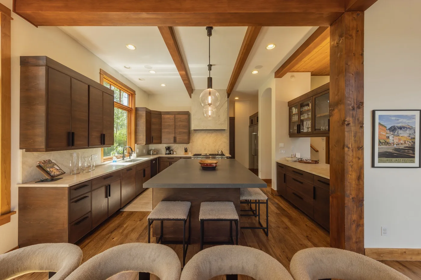 A spacious kitchen with dark wood cabinetry, a central island, and pendant lighting.