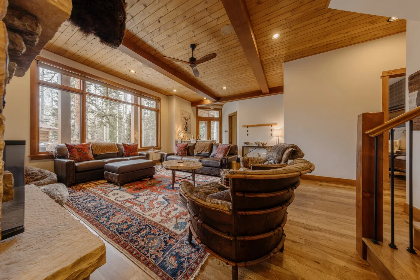 A spacious living room with seating around a coffee table beside large windows.
