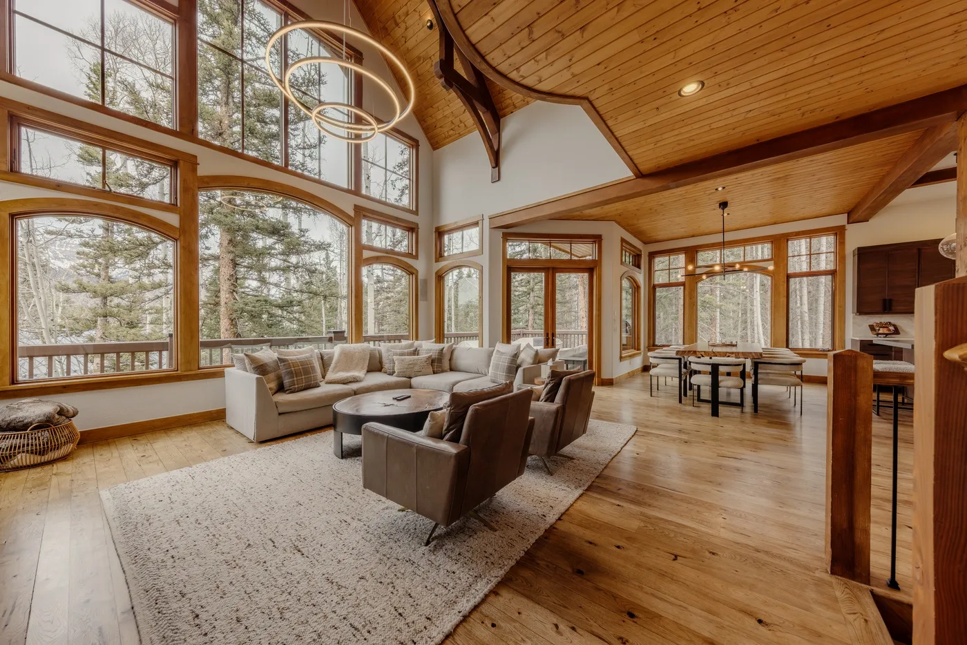A bright living and dining area with large windows and seating.