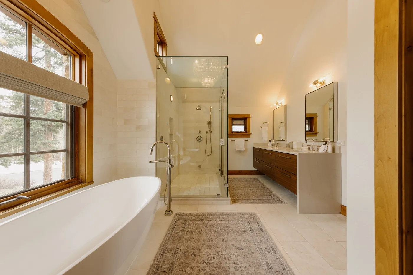 A spacious bathroom with a freestanding bathtub, glass shower, and double vanity.