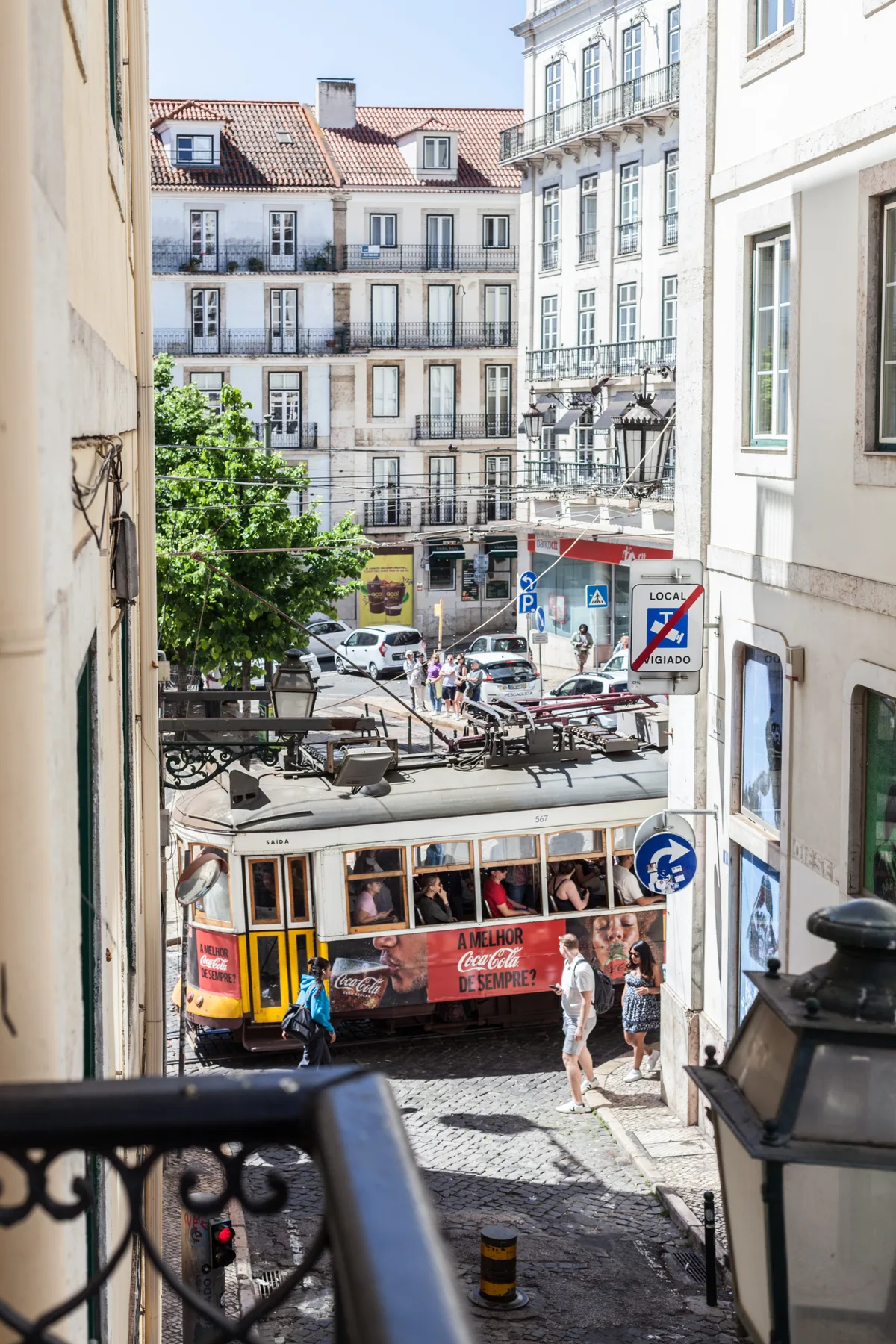 A city street with a tram passing between buildings.