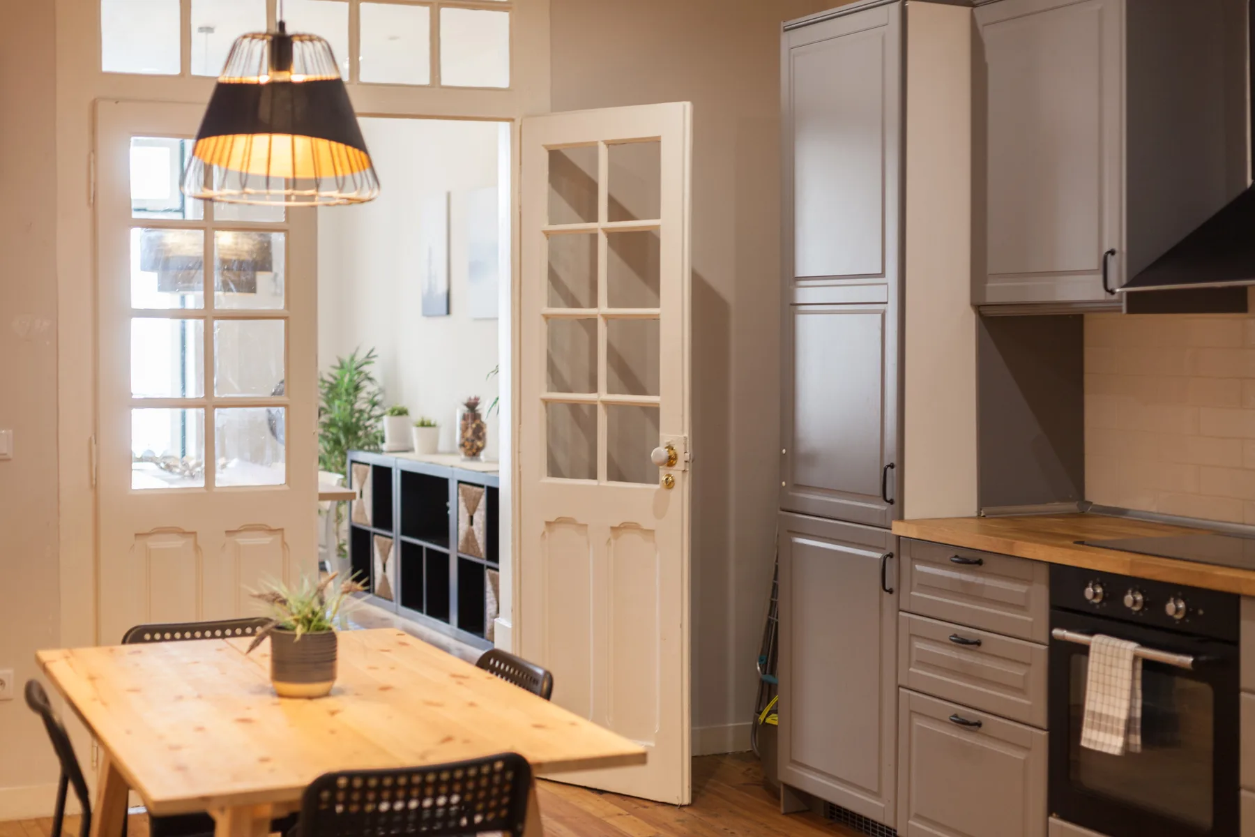 A dining area with a wooden table beside an open kitchen.