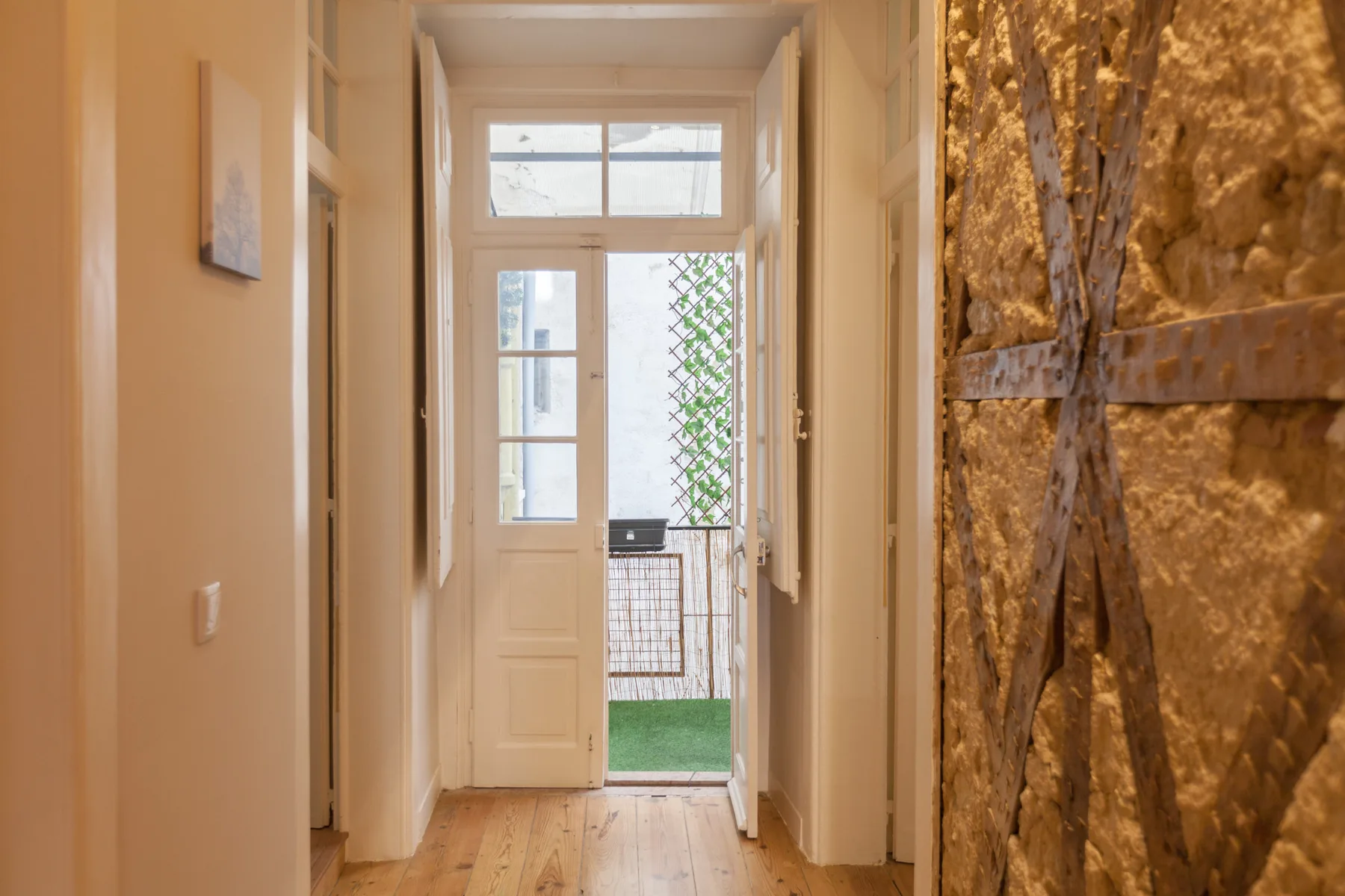 A hallway leads to a glazed door opening onto a small outdoor area.