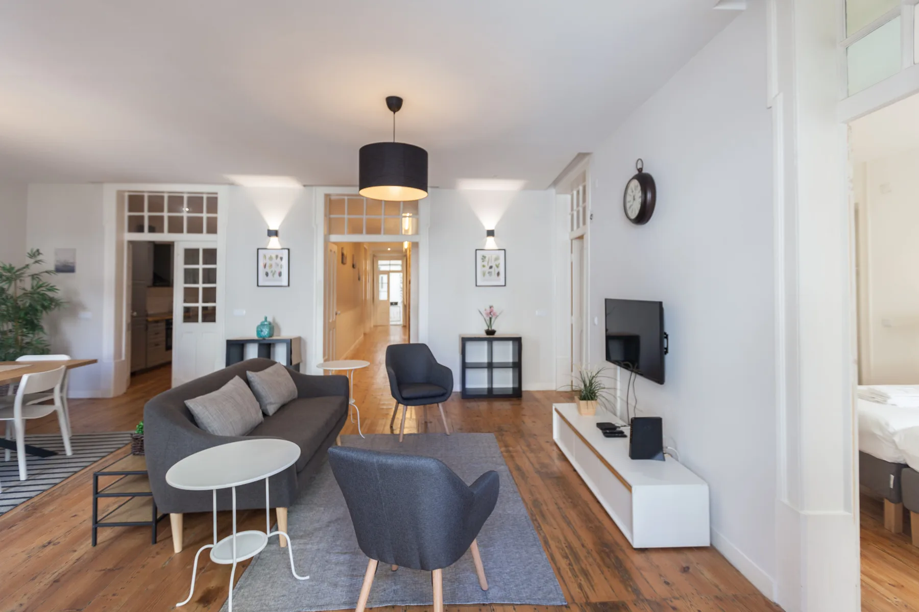 A bright living room with seating, a television, and a dining area.