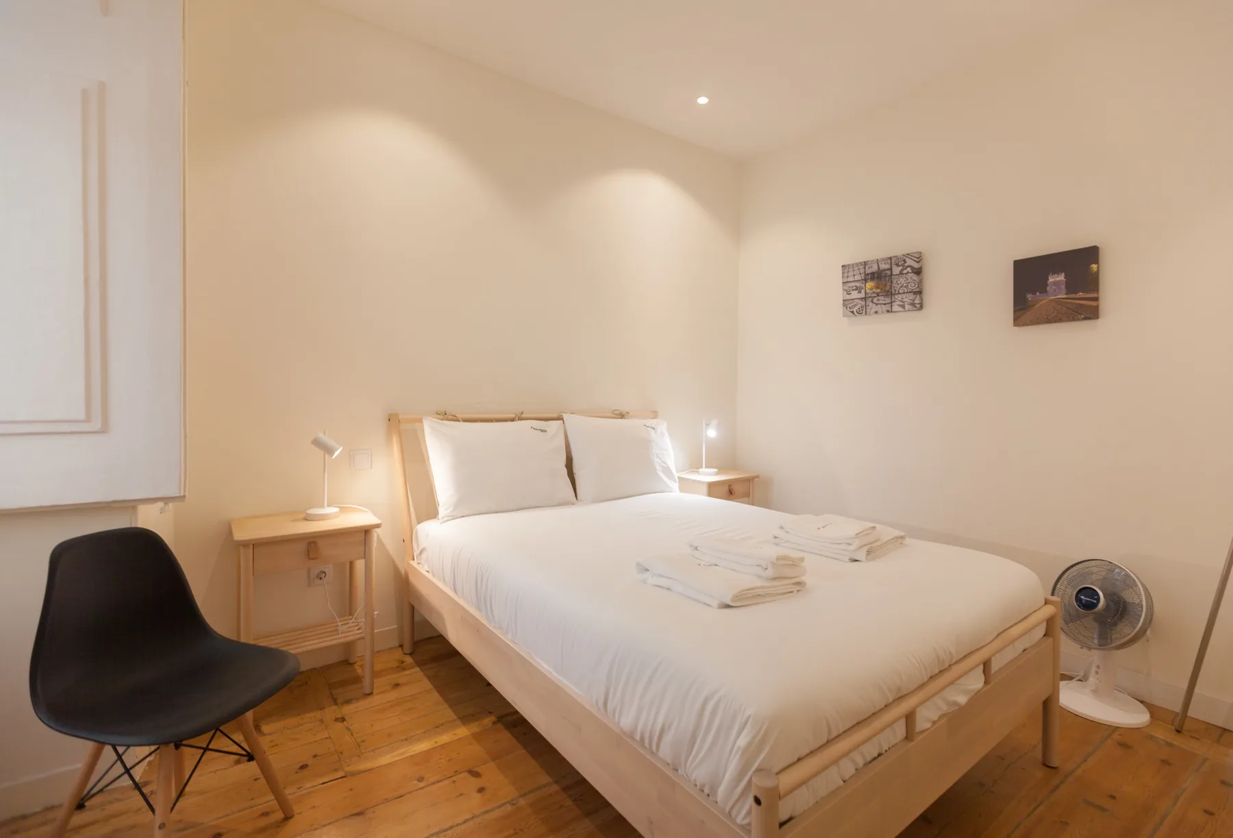 A bedroom with a bed, bedside tables, and a chair.
