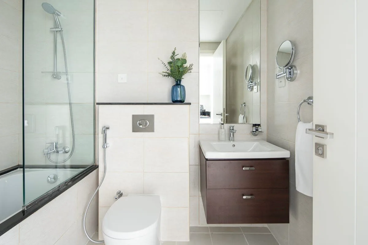 Un baño moderno con ducha de vidrio, inodoro y lavabo.