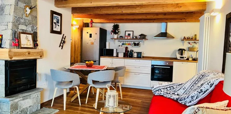 An open-plan living and dining area with a kitchen and fireplace.