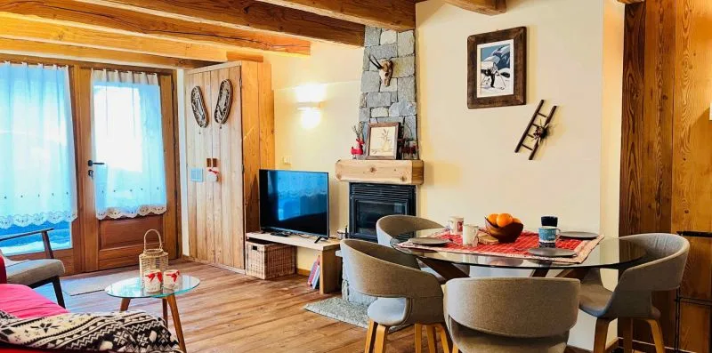 A wood-paneled living and dining room with a television and table.