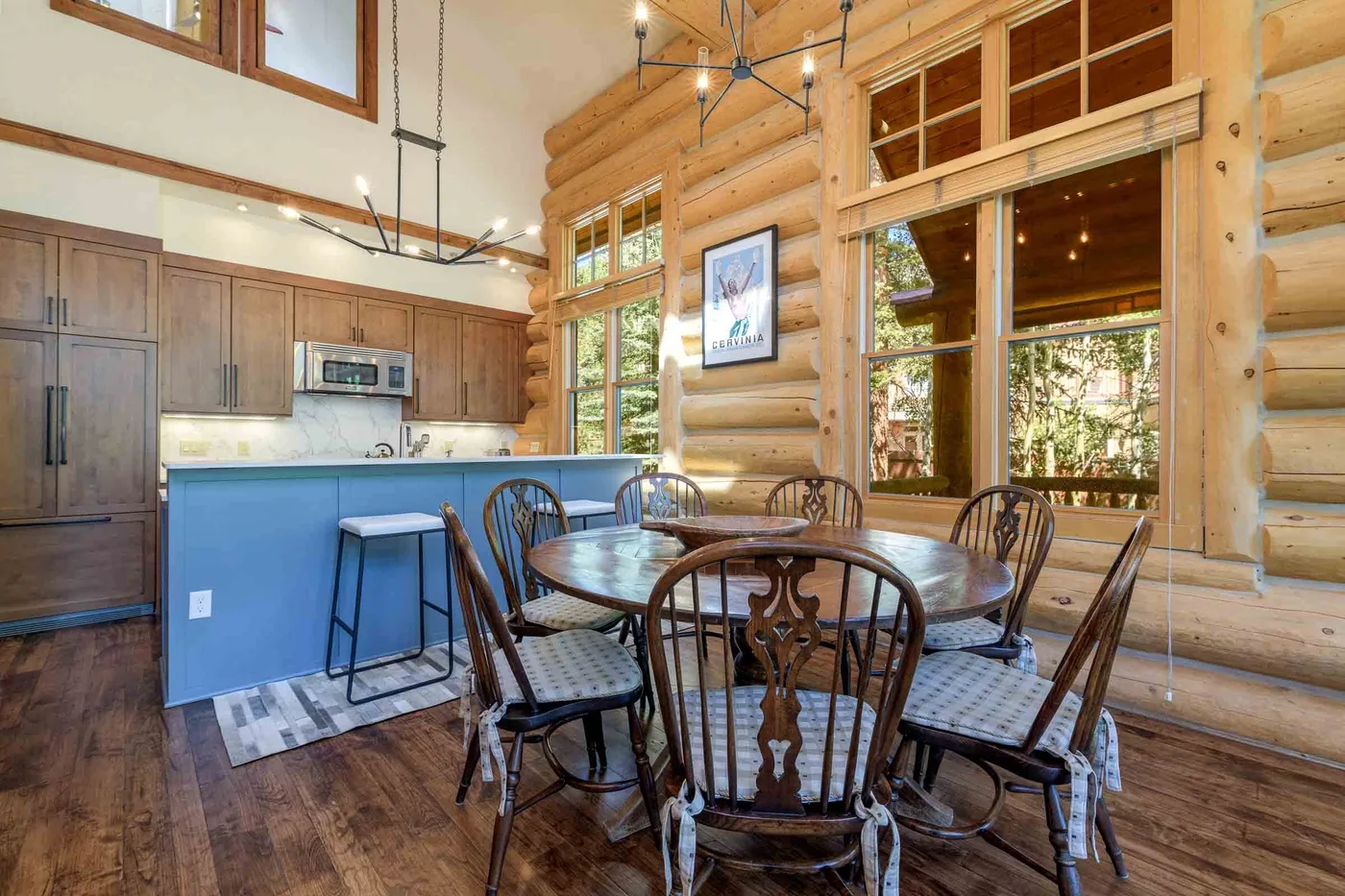 A dining area with a round table and chairs beside an open kitchen.