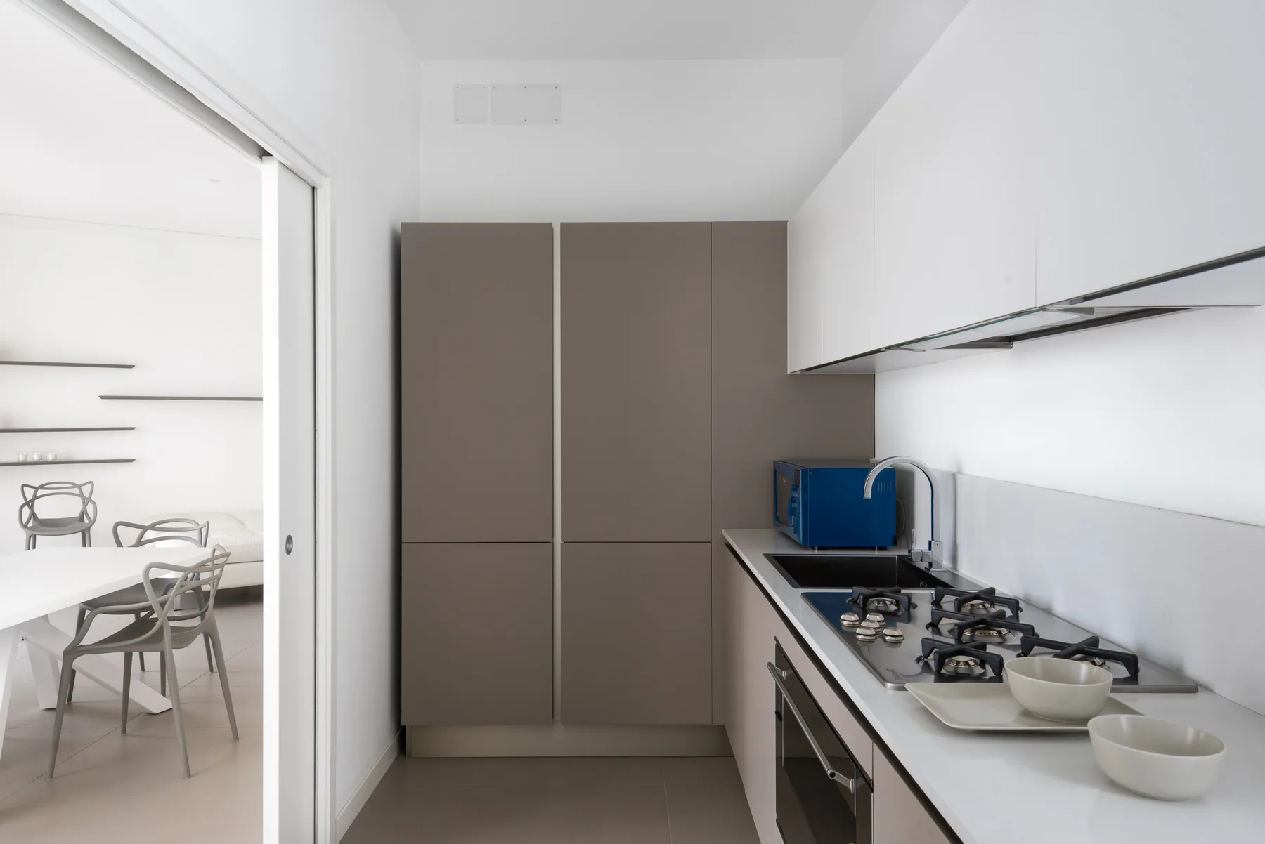 A modern kitchen with a long countertop and tall cabinets.