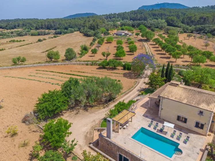 Una vista aérea muestra una propiedad rural con piscina y campos alrededor.