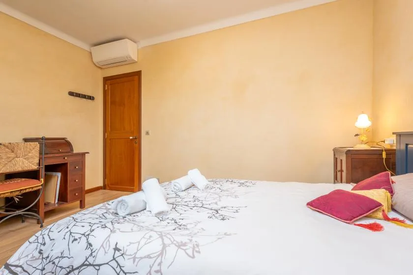Un dormitorio con una cama bien hecha y muebles de madera.