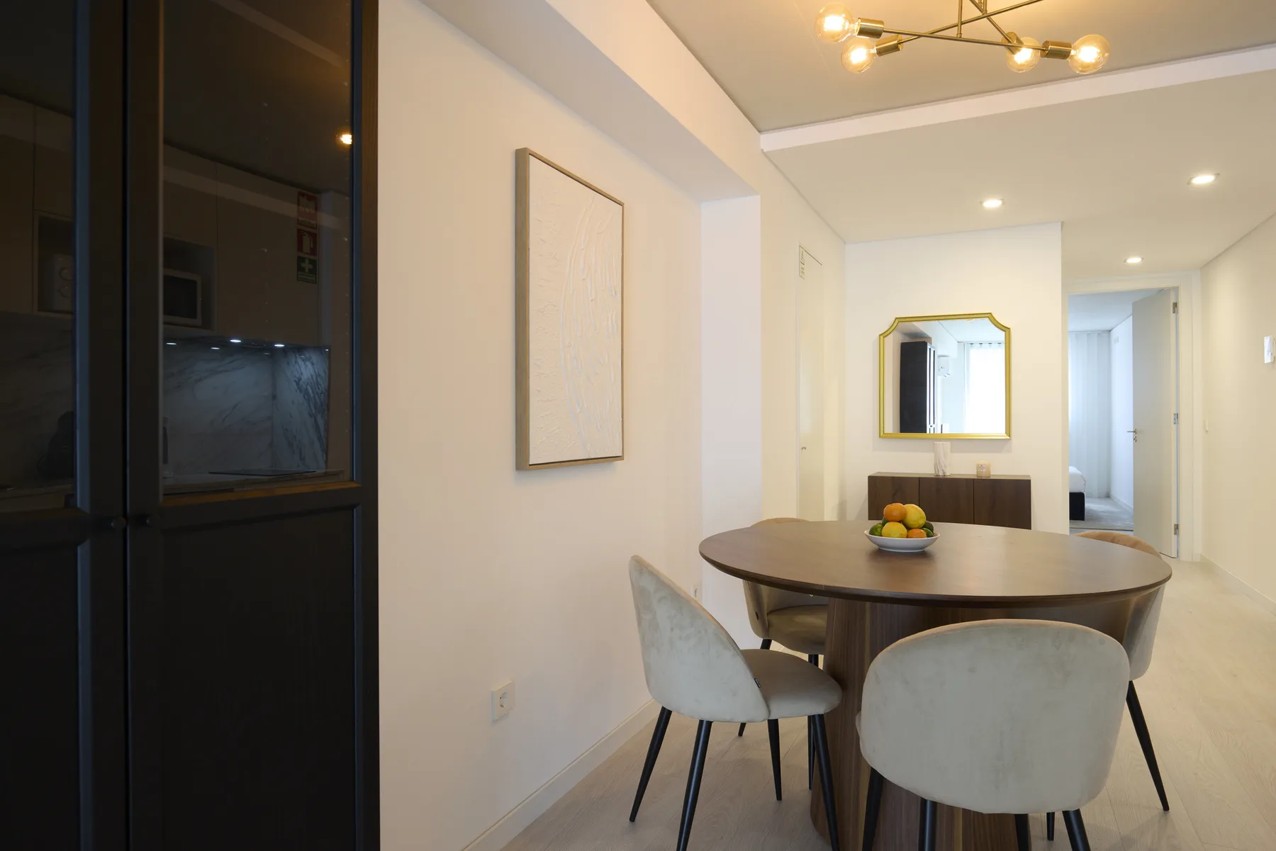 Comedor con una mesa redonda y sillas junto a una cocina.