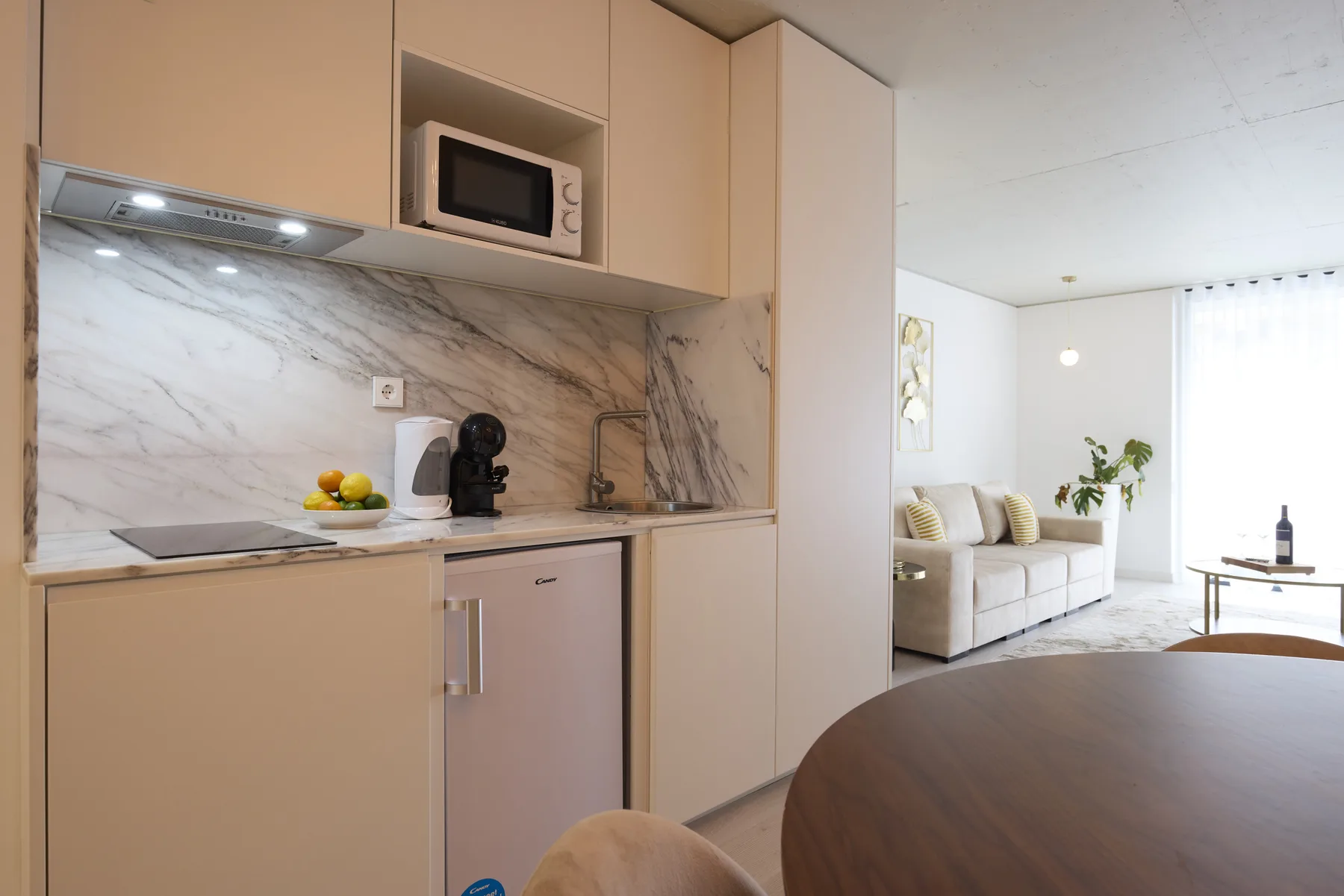Cocina y sala de estar de concepto abierto con mesa de comedor y sofá.