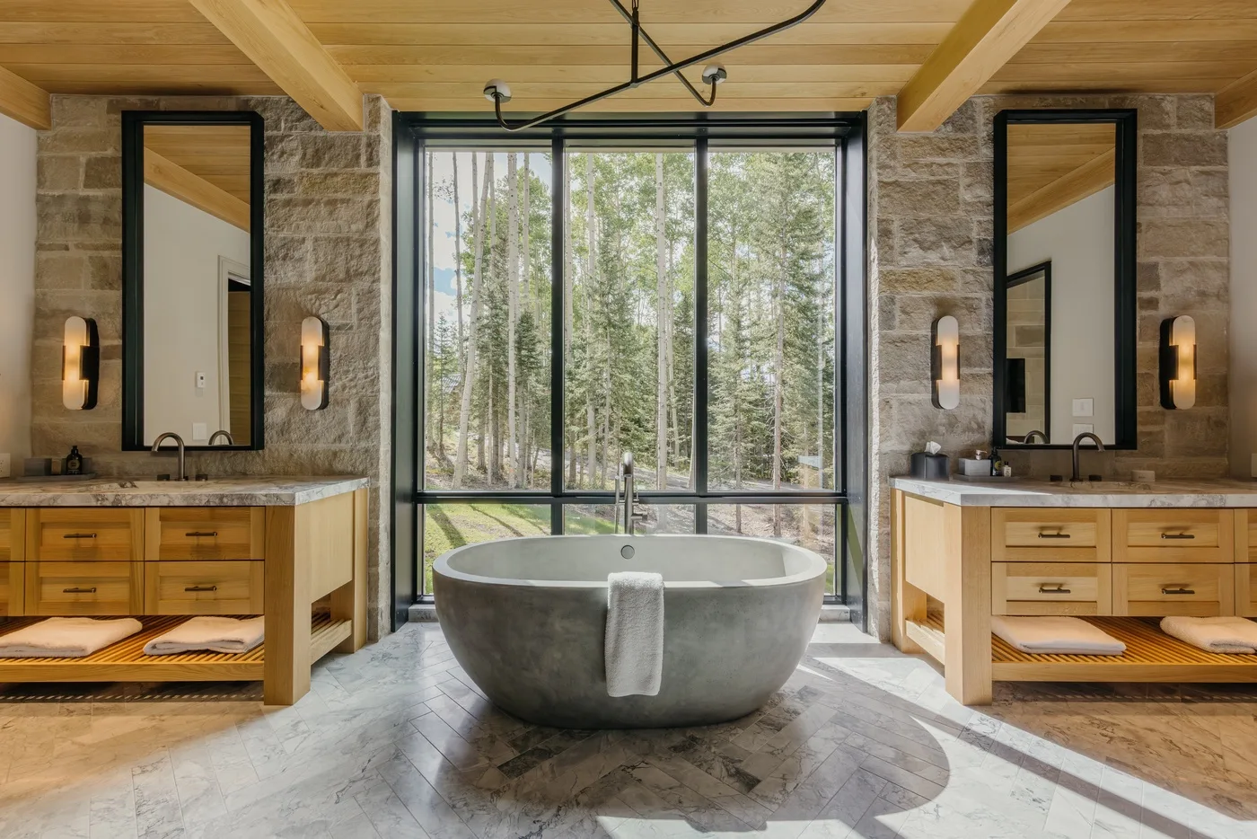 A bathroom with a freestanding bathtub in front of a large window.
