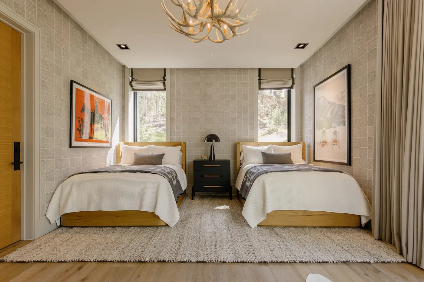 A bedroom with two beds, a nightstand, and framed artwork.