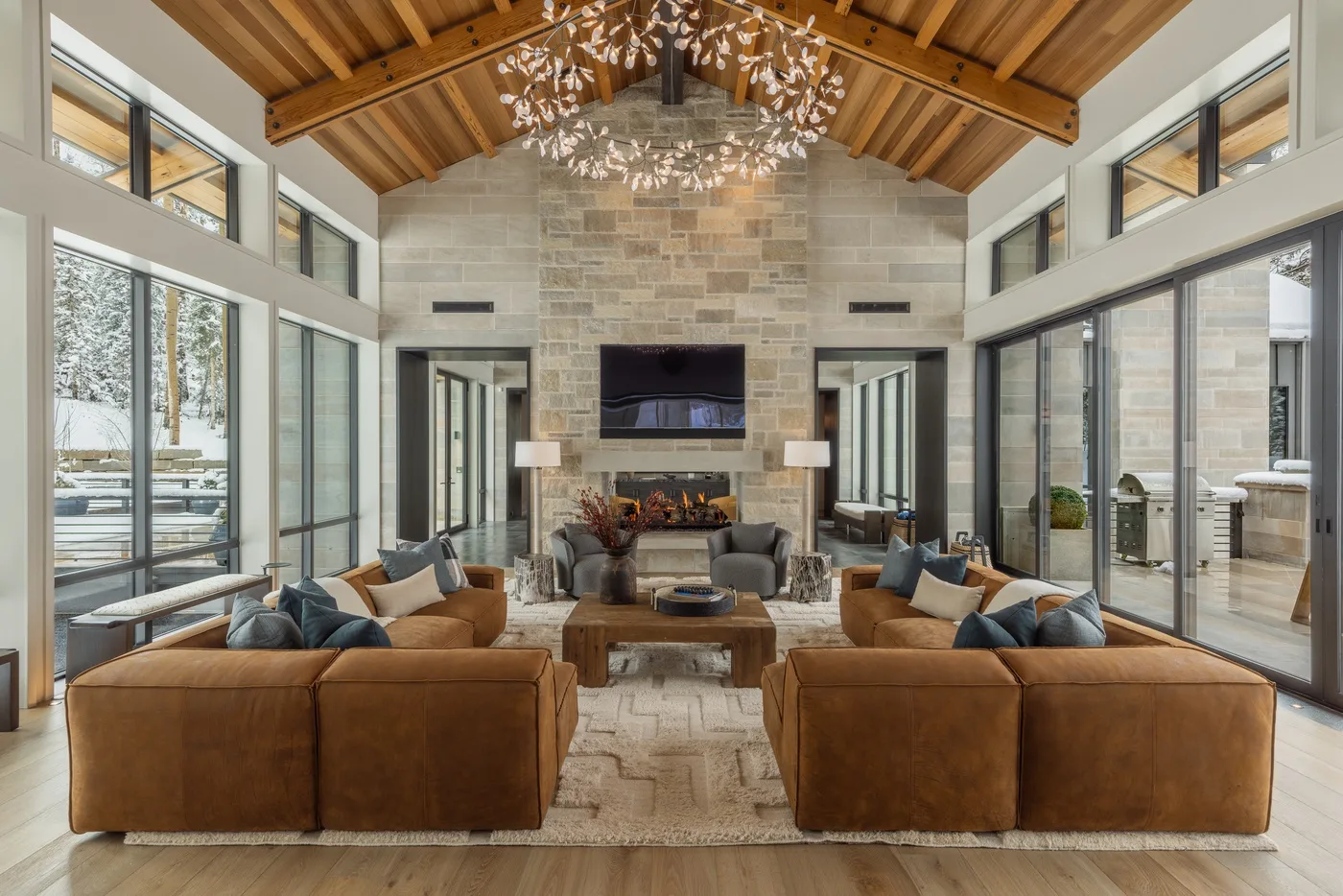 A spacious living room with seating arranged around a fireplace and television.