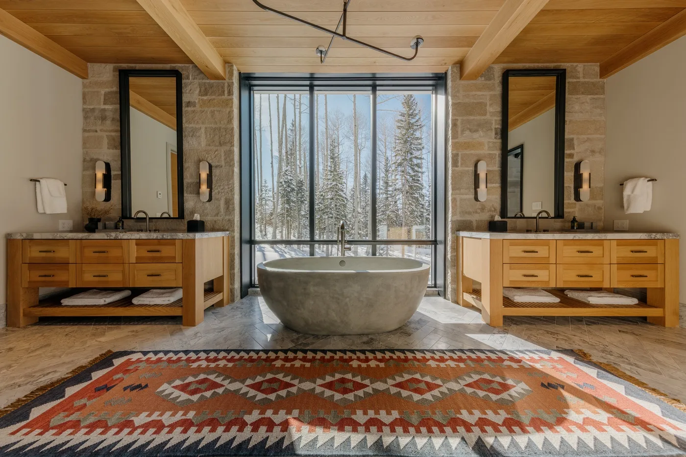 A bathroom with a freestanding tub, twin vanities, and a large window.