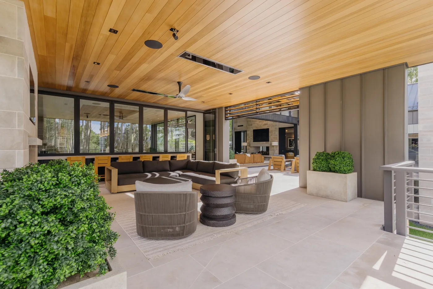 Covered lounge area with seating and large windows.