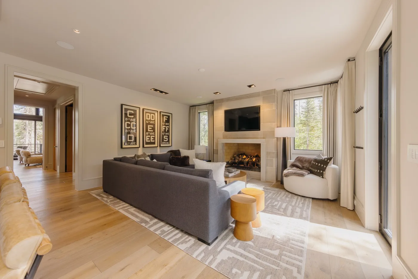 A bright living room with seating arranged around a fireplace and television.