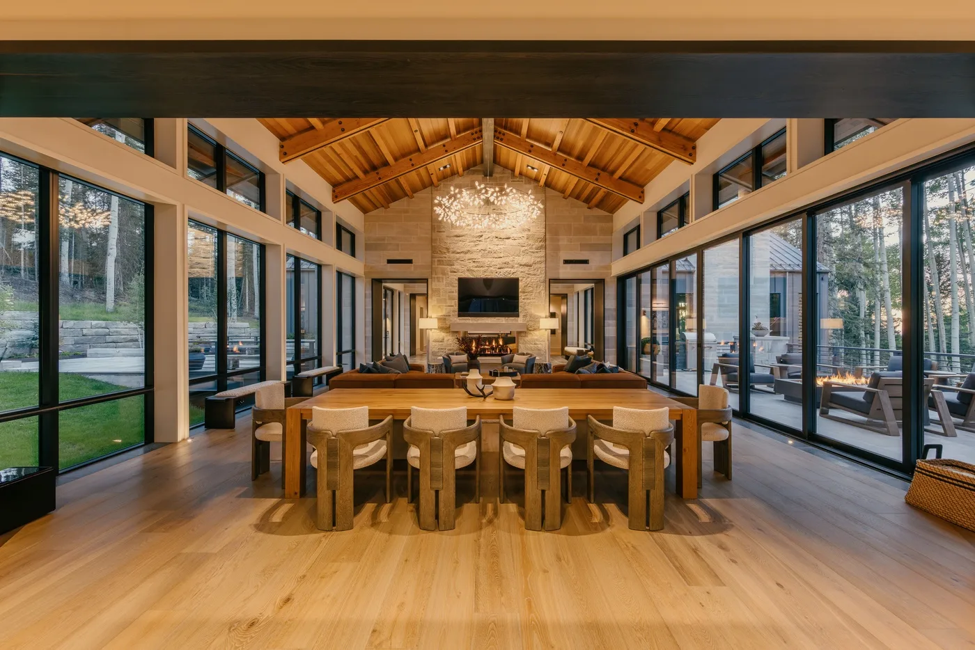 A dining area with a long wooden table and seating beneath a vaulted timber ceiling.