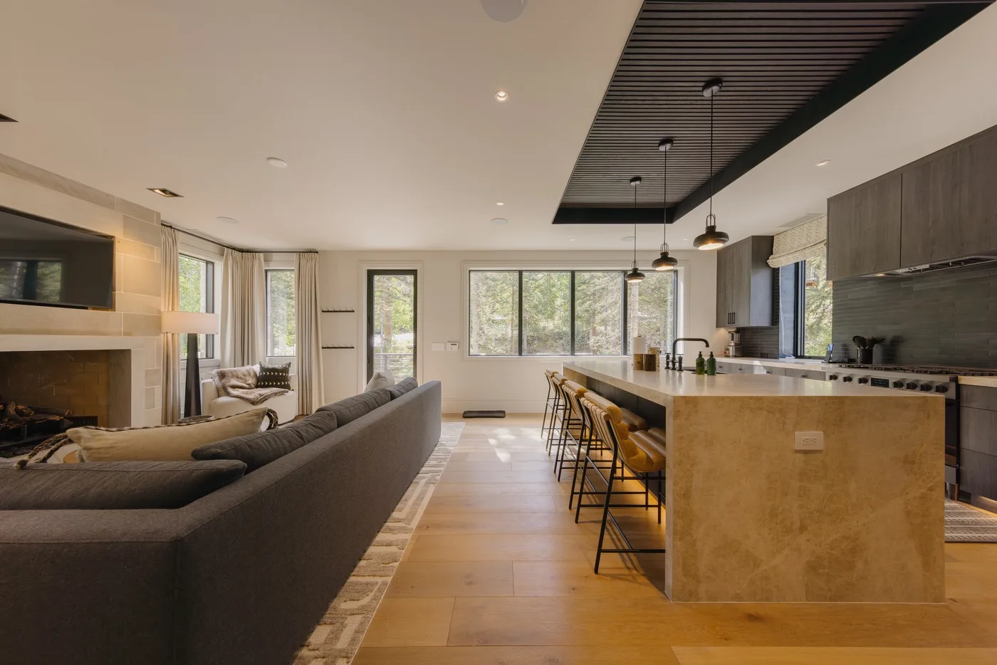 An open-plan living room and kitchen with a long island and seating.