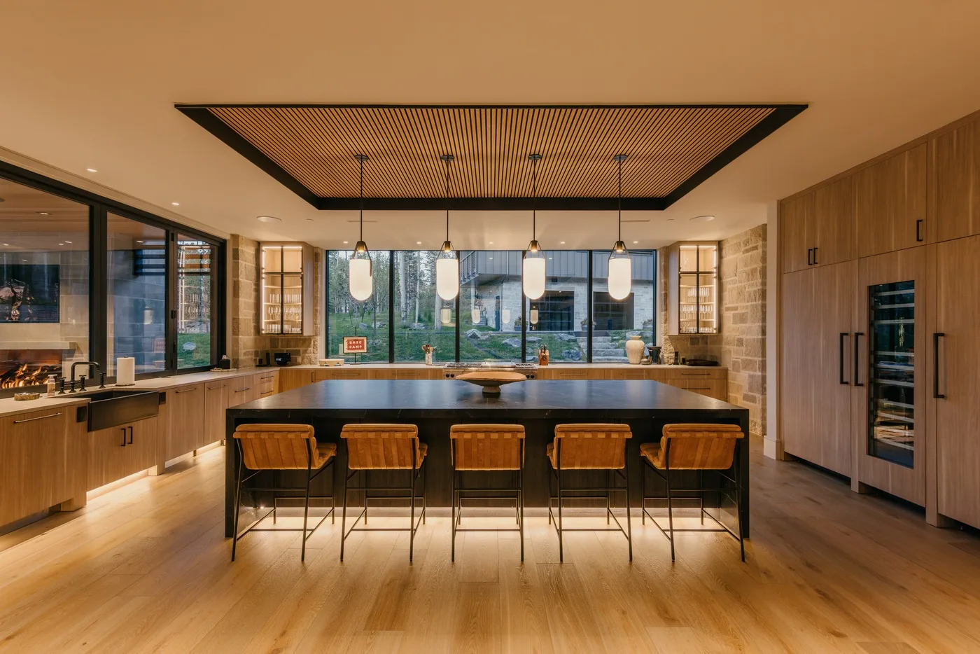 A spacious kitchen with a central island, wooden cabinetry, and pendant lights.