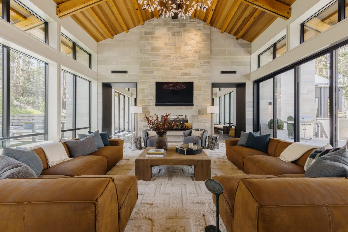 A spacious living room with seating around a central coffee table and fireplace.