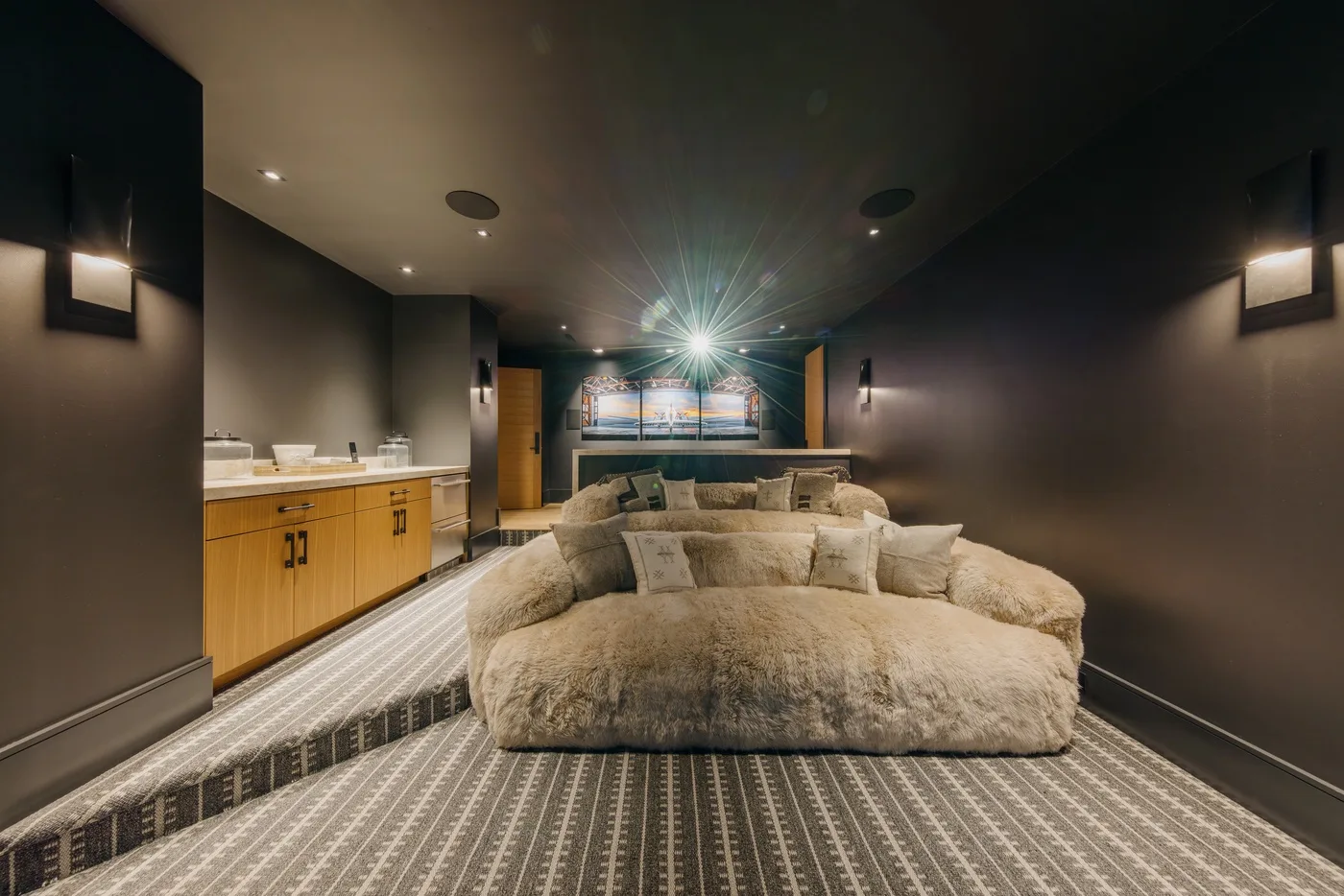 A dim lounge features a large rounded seating area and a long counter.