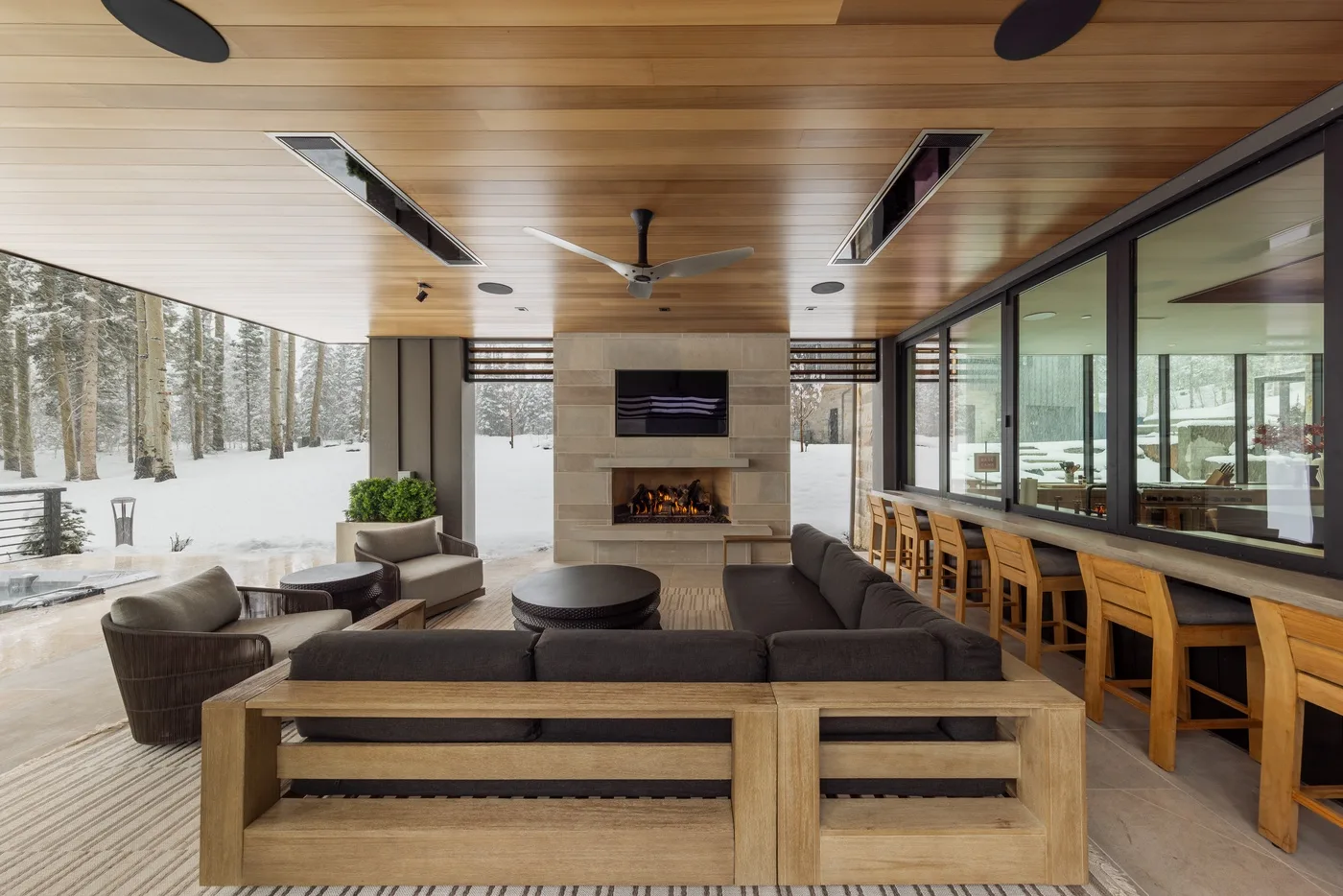 A spacious lounge with seating around a fireplace and a long counter.