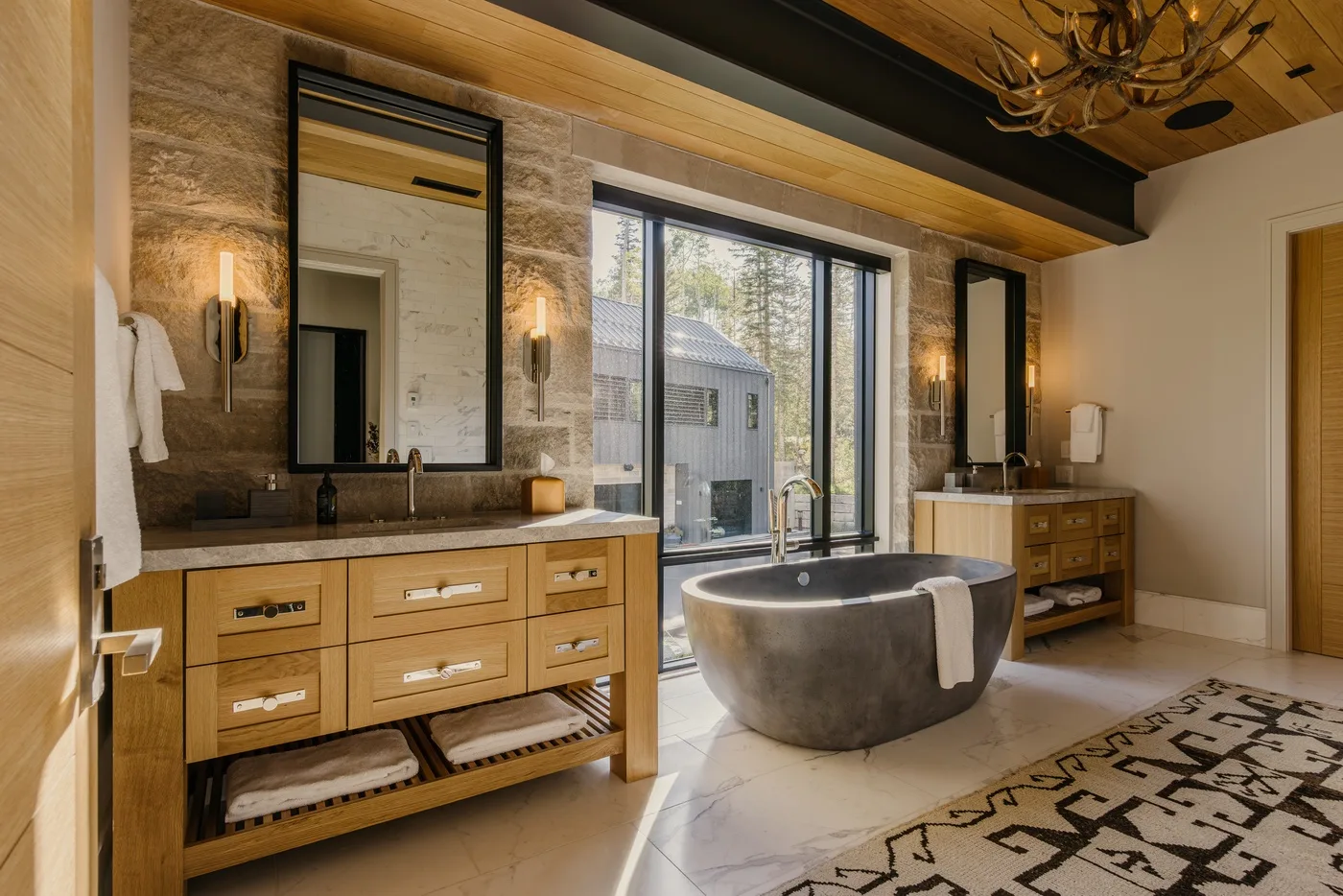 A spacious bathroom features a freestanding bathtub beside large windows.
