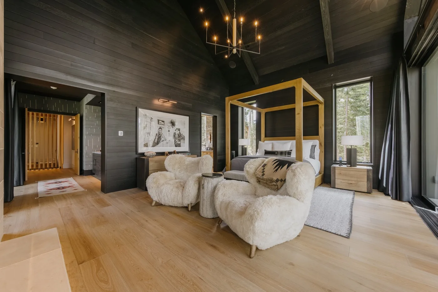 A bedroom seating area with a four-poster bed and upholstered chairs.