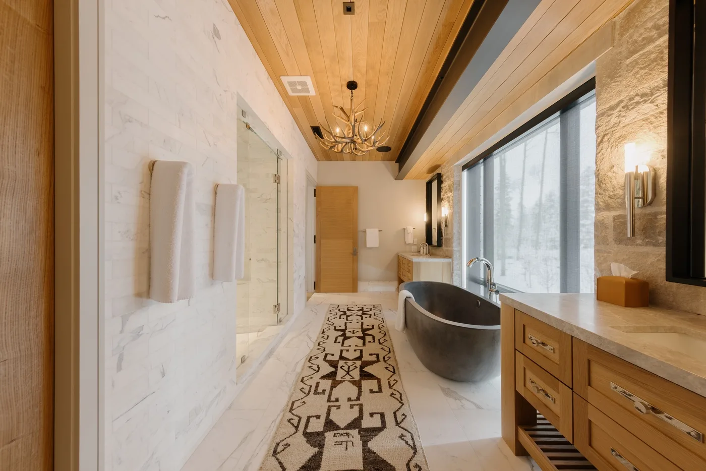A spacious bathroom with a freestanding tub beside a large window.