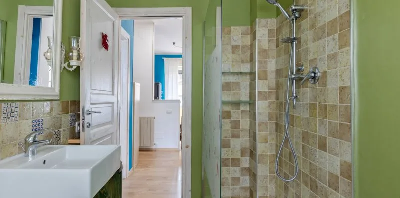 Un baño con lavabo y una zona de ducha con azulejos.
