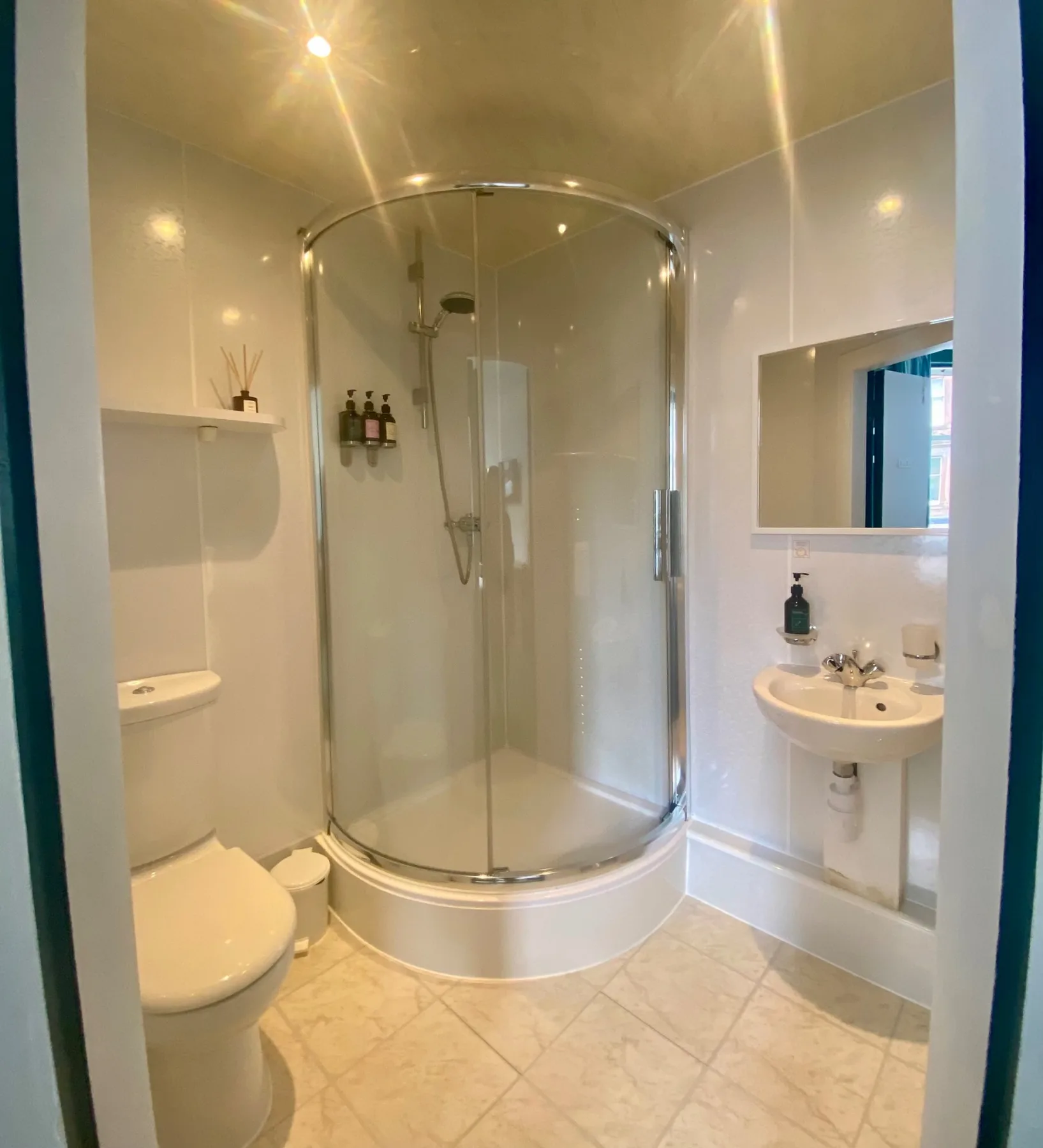 Baño con ducha, inodoro y lavabo.