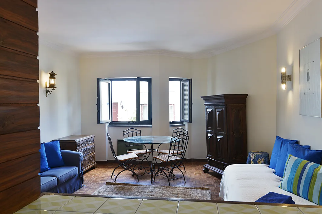 A living and dining room with seating, a table, and windows.