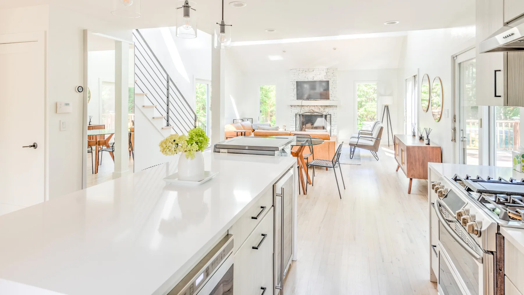 Una luminosa cocina abierta al salón, con una larga isla blanca.