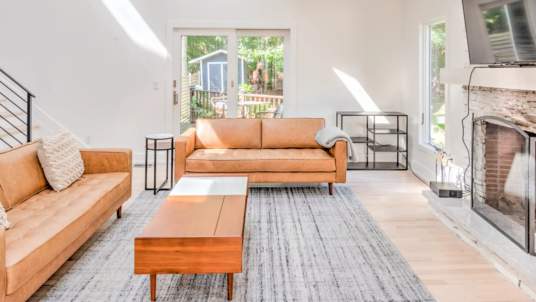Una sala de estar luminosa con asientos, una mesa de centro y una chimenea.