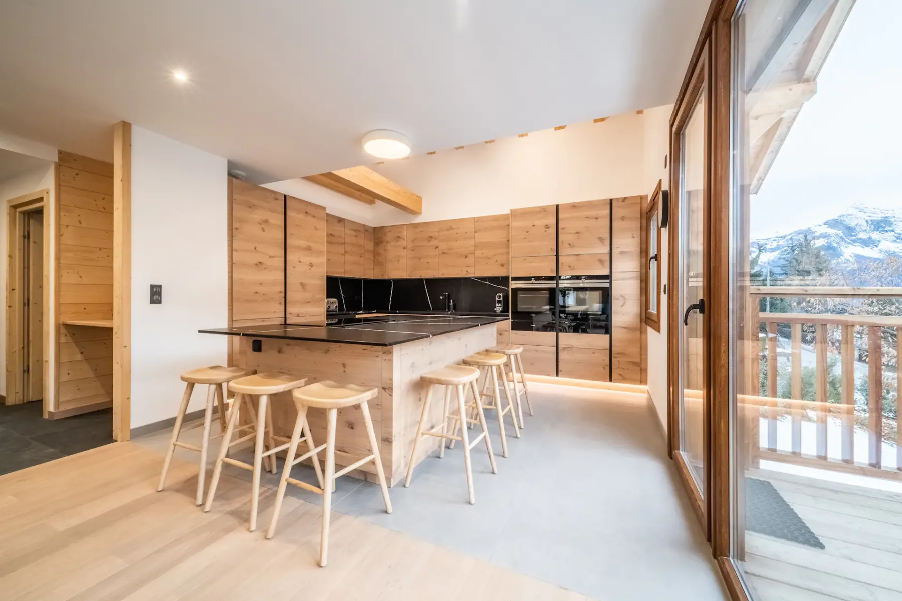 A contemporary kitchen with a central island and large windows.