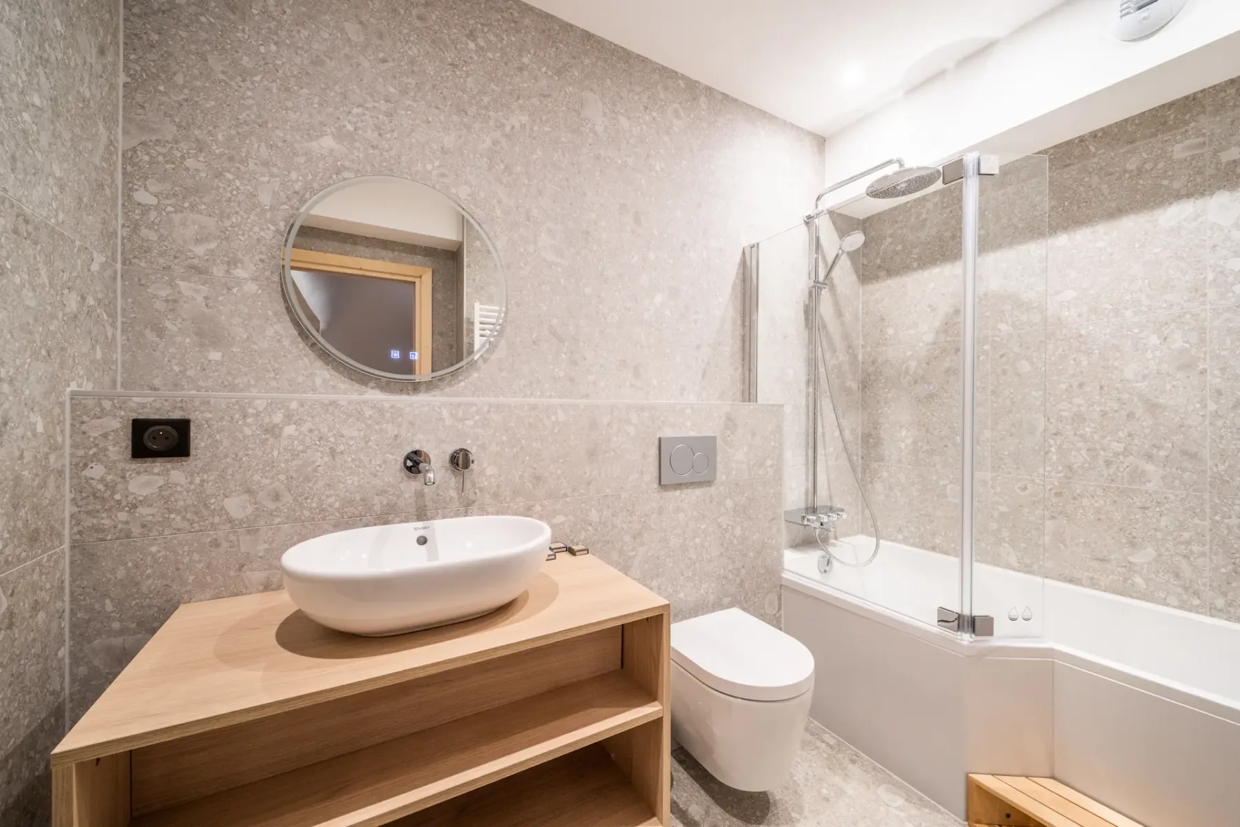 A tiled bathroom with a sink, toilet, and bathtub with a shower.