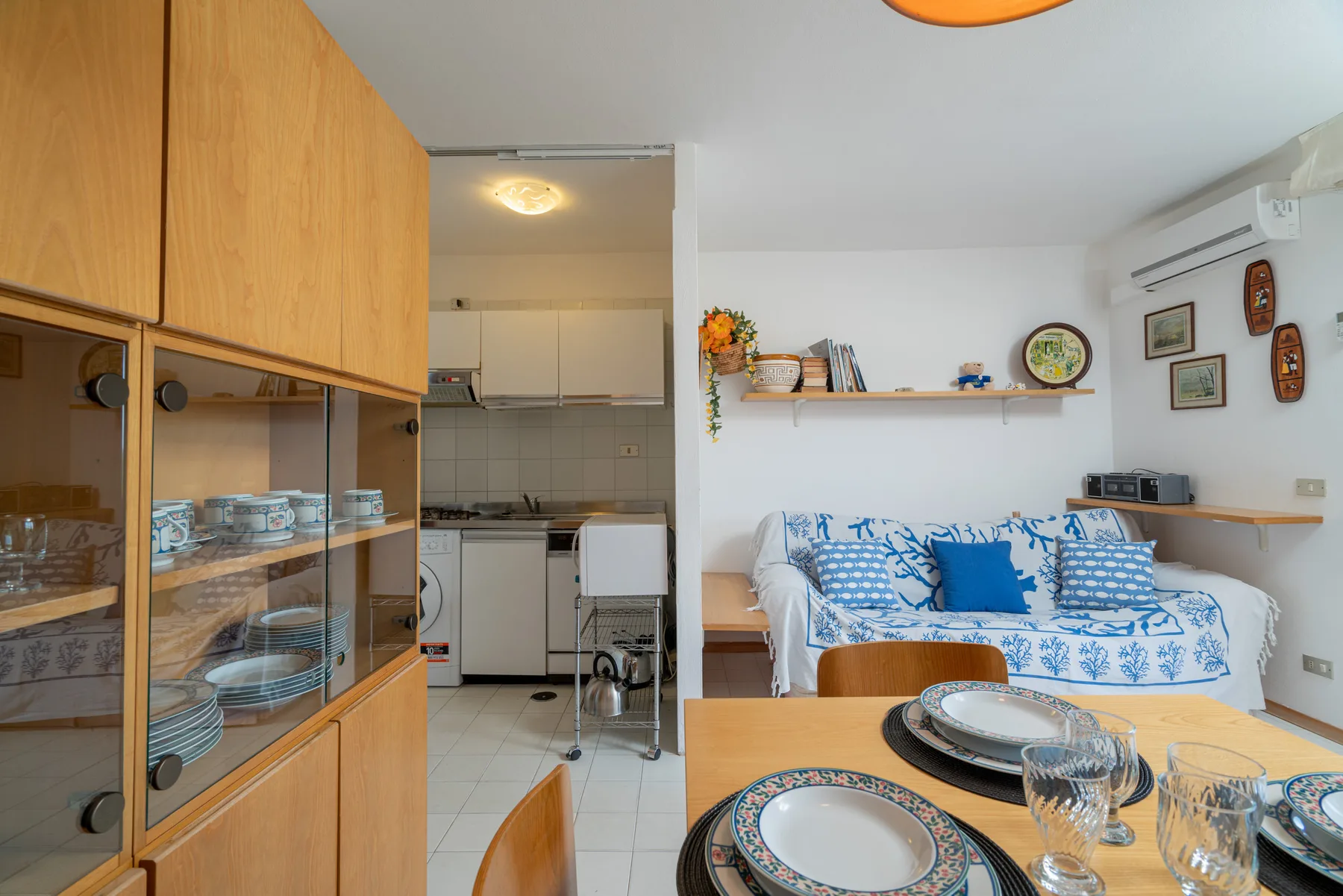 Una cocina y comedor con una zona de estar de estampado azul junto a la mesa.