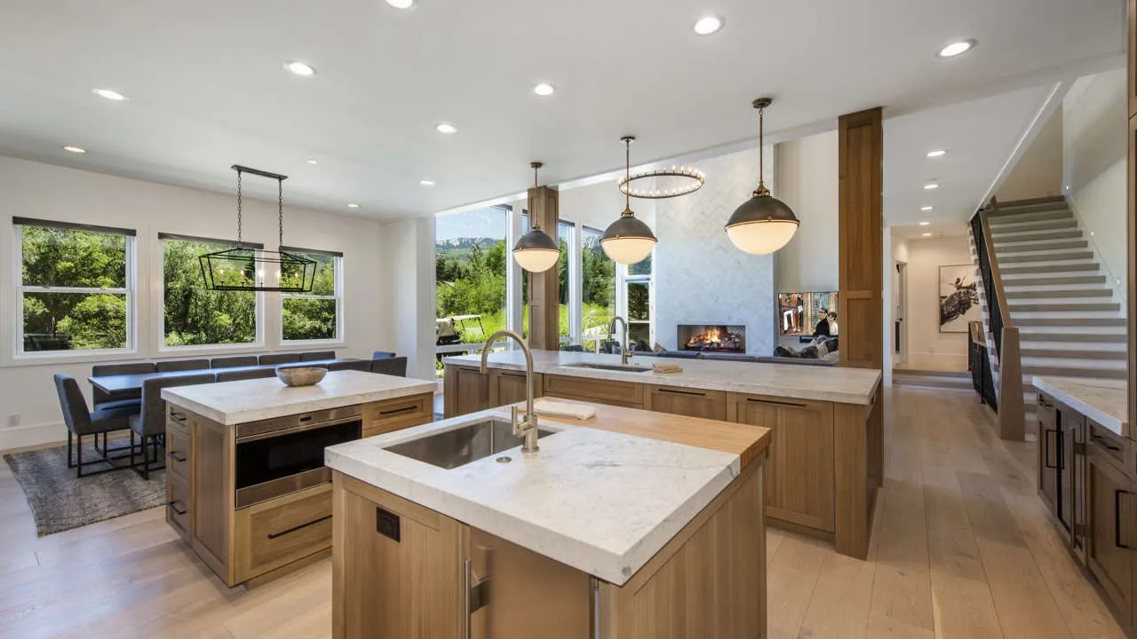 A bright open-plan kitchen and dining area with a large island and pendant lights.