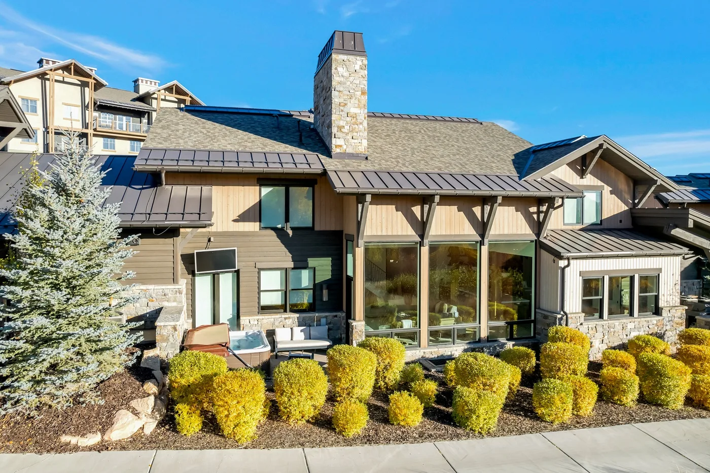 A lodge-style building with broad windows and trimmed shrubs along the front.
